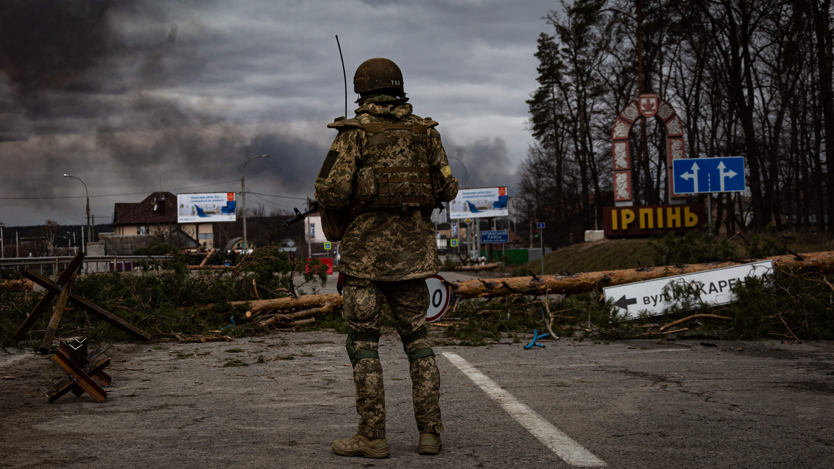 Ukrainian soldier looking over destructions in Irpin, Ukraine